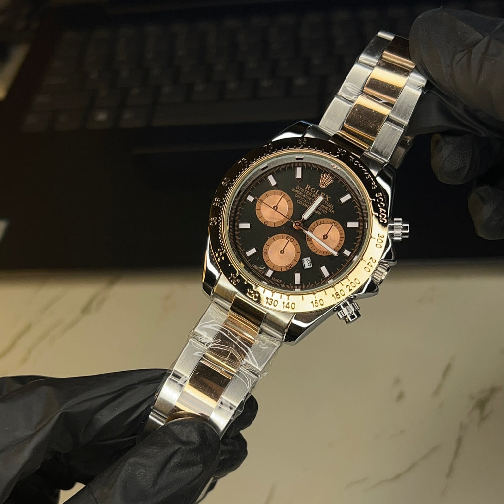 Two-tone black dial watch worn on wrist